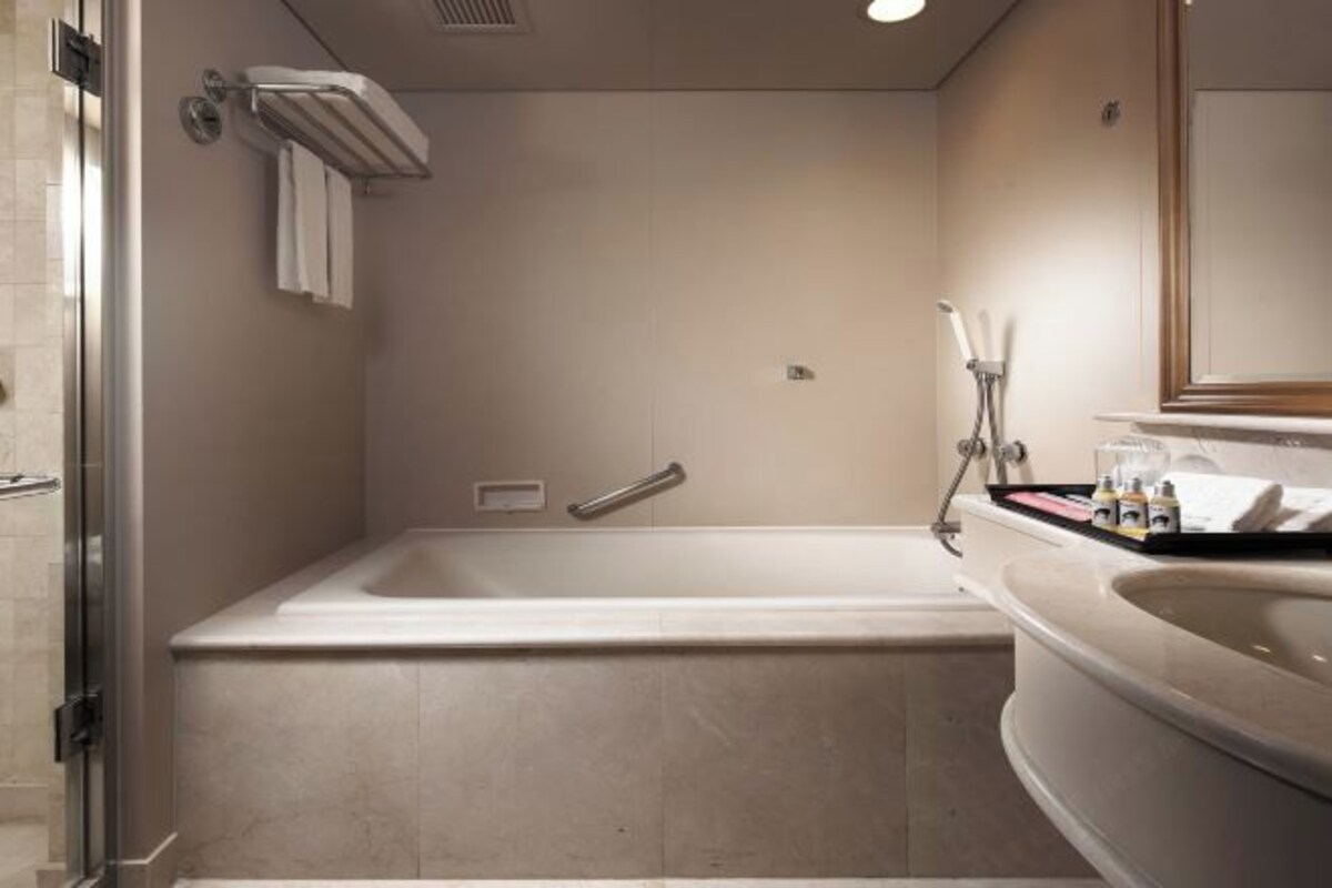 Un baño moderno con bañera, zona de ducha y lavabo.