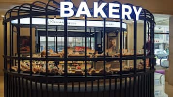 A bakery display with a sign reading "BAKERY" and various baked goods on shelves.
