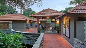 A resort with multiple buildings, outdoor seating areas, and a pool. - Angsana Oasis Spa & Resort (Bengaluru)