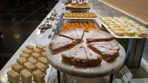 A buffet with various desserts and a sign indicating ice cream. - Angsana Oasis Spa & Resort (Bengaluru)