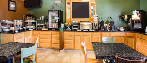 A kitchen with wooden cabinets, a black countertop, and a coffee machine.