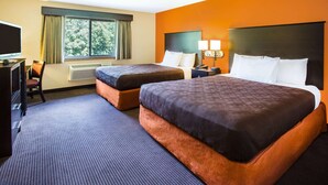 A hotel room with two beds, a desk with a TV, and a window with curtains. - AmericInn by Wyndham Menomonie (Menomonie)