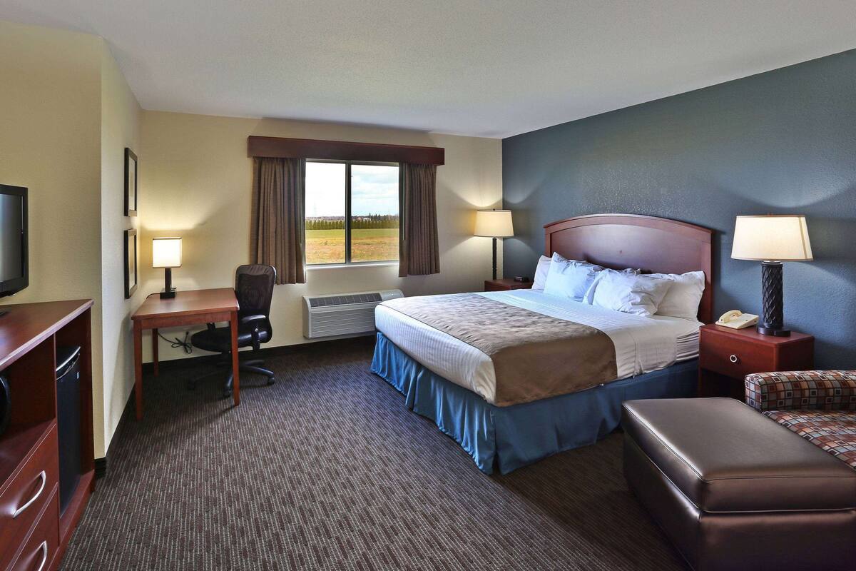 Une chambre d’hôtel équipée d’un lit, d’un bureau, d’une chaise et d’un téléviseur.