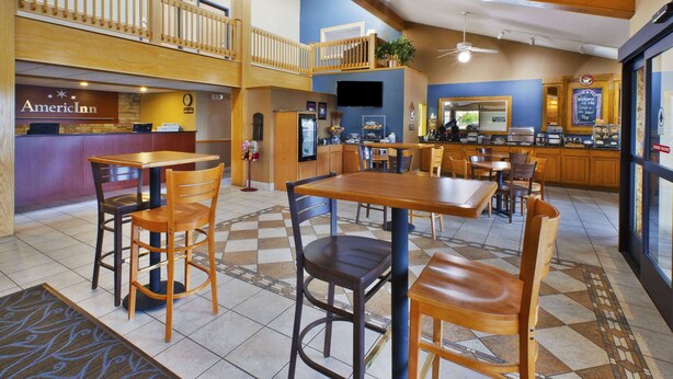 Un hall de hotel con mostrador de recepción, zona de estar y kitchenette.