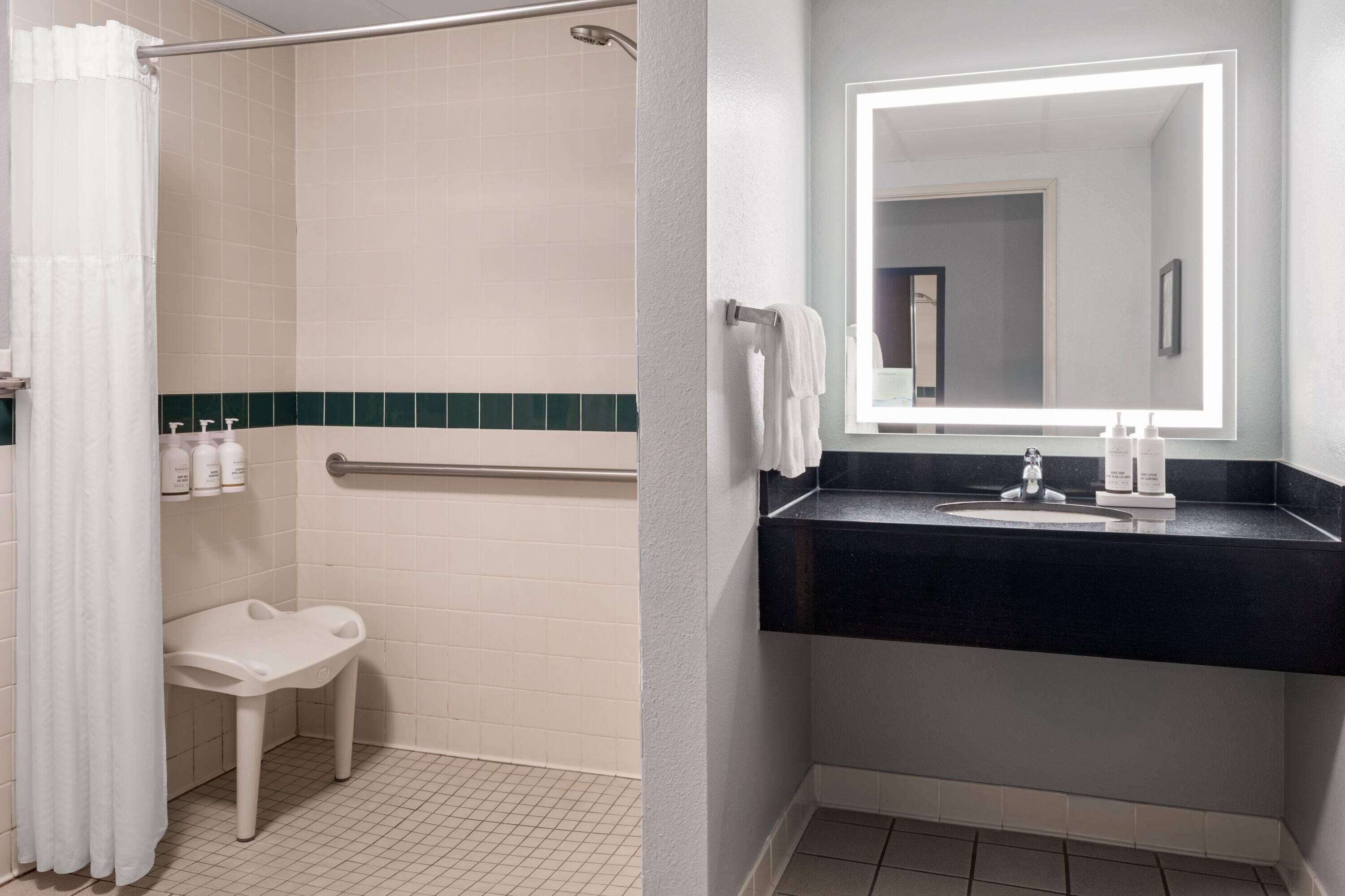 Un baño con ducha, inodoro, lavabo y espejo.