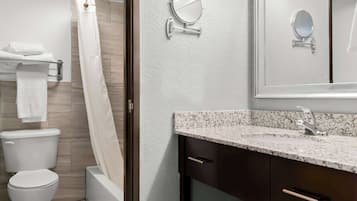 A modern bathroom with a toilet, shower, and sink.