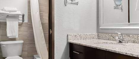 A modern bathroom with a toilet, shower, and sink.