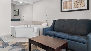 Un baño moderno con una bañera, un sofá azul y un cuadro enmarcado en la pared.
