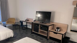A hotel room with a bed, a desk with a TV, a microwave, and a coffee maker. - City Express by Marriott Louisville Southeast (Louisville)