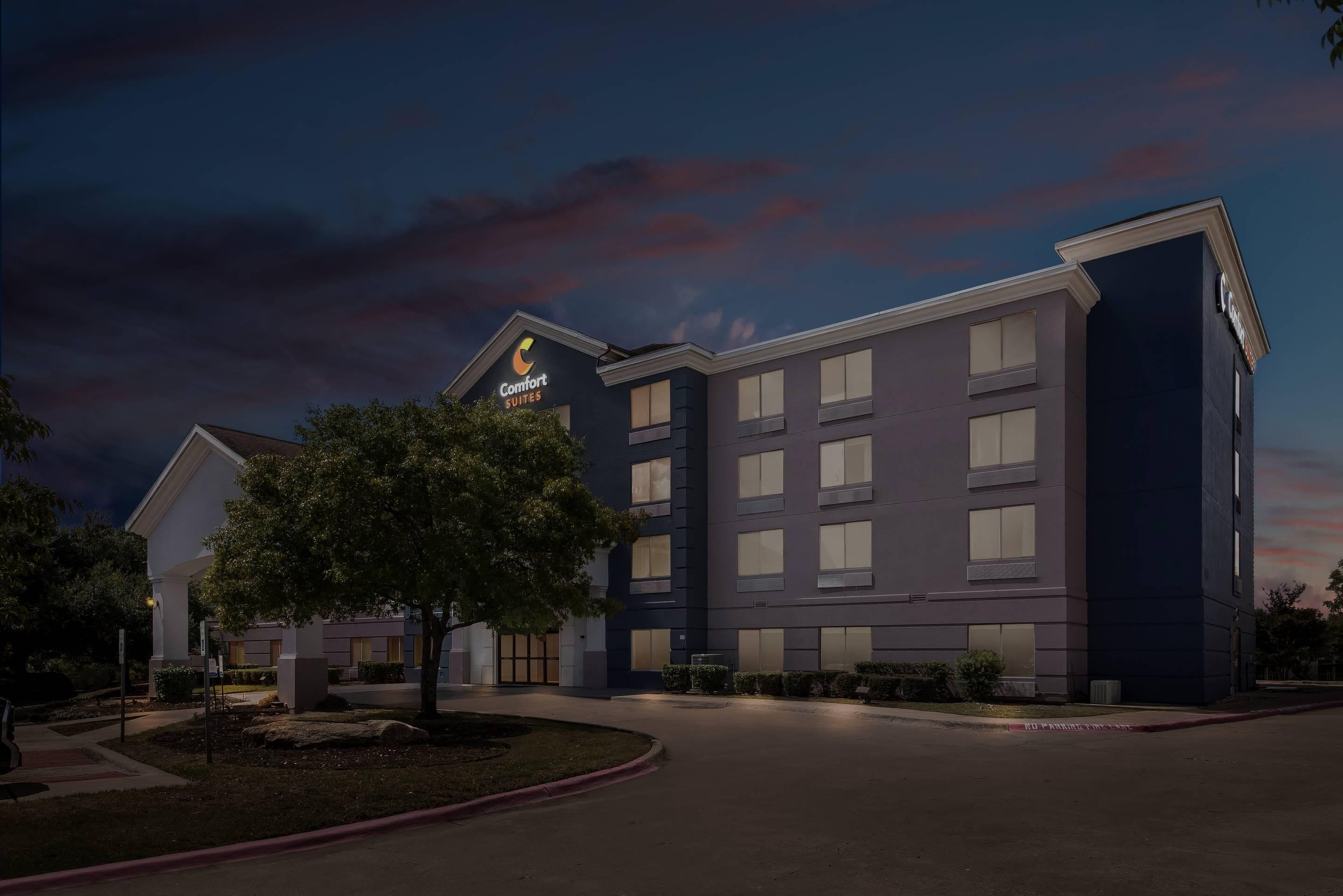 A hotel with a modern design, featuring a prominent sign for Comfort Suites.