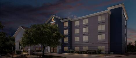 A hotel with a modern design, featuring a prominent sign for Comfort Suites.