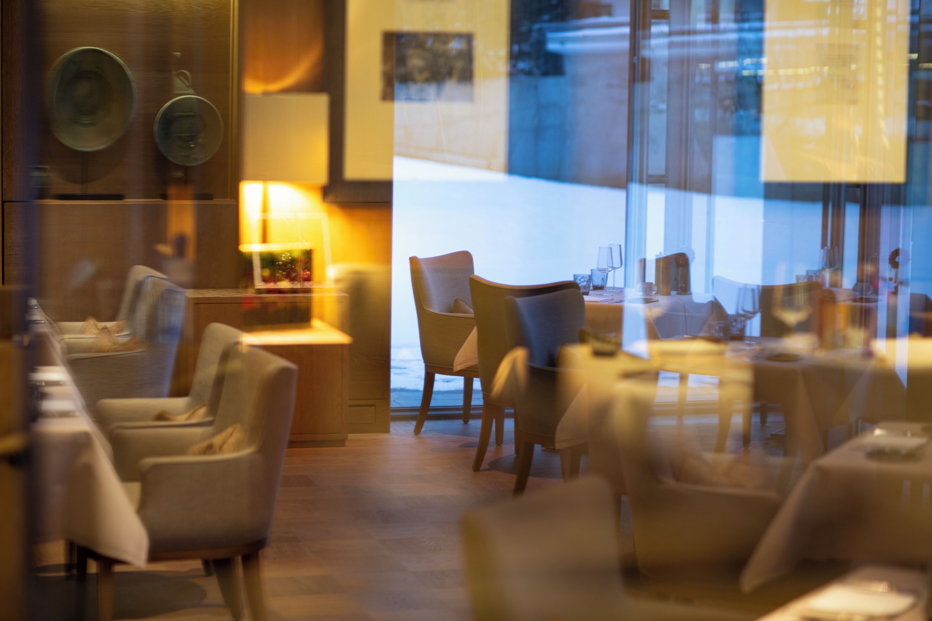 Ein Restaurant mit modernem Interieur, das unterschiedliche Sitzmöglichkeiten wie Tische und Stühle bietet.