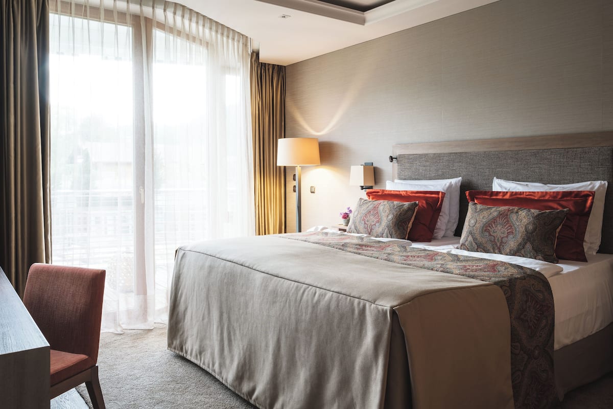 Ein Hotelzimmer mit einem großen Bett, einem Schreibtisch und einem Stuhl.
