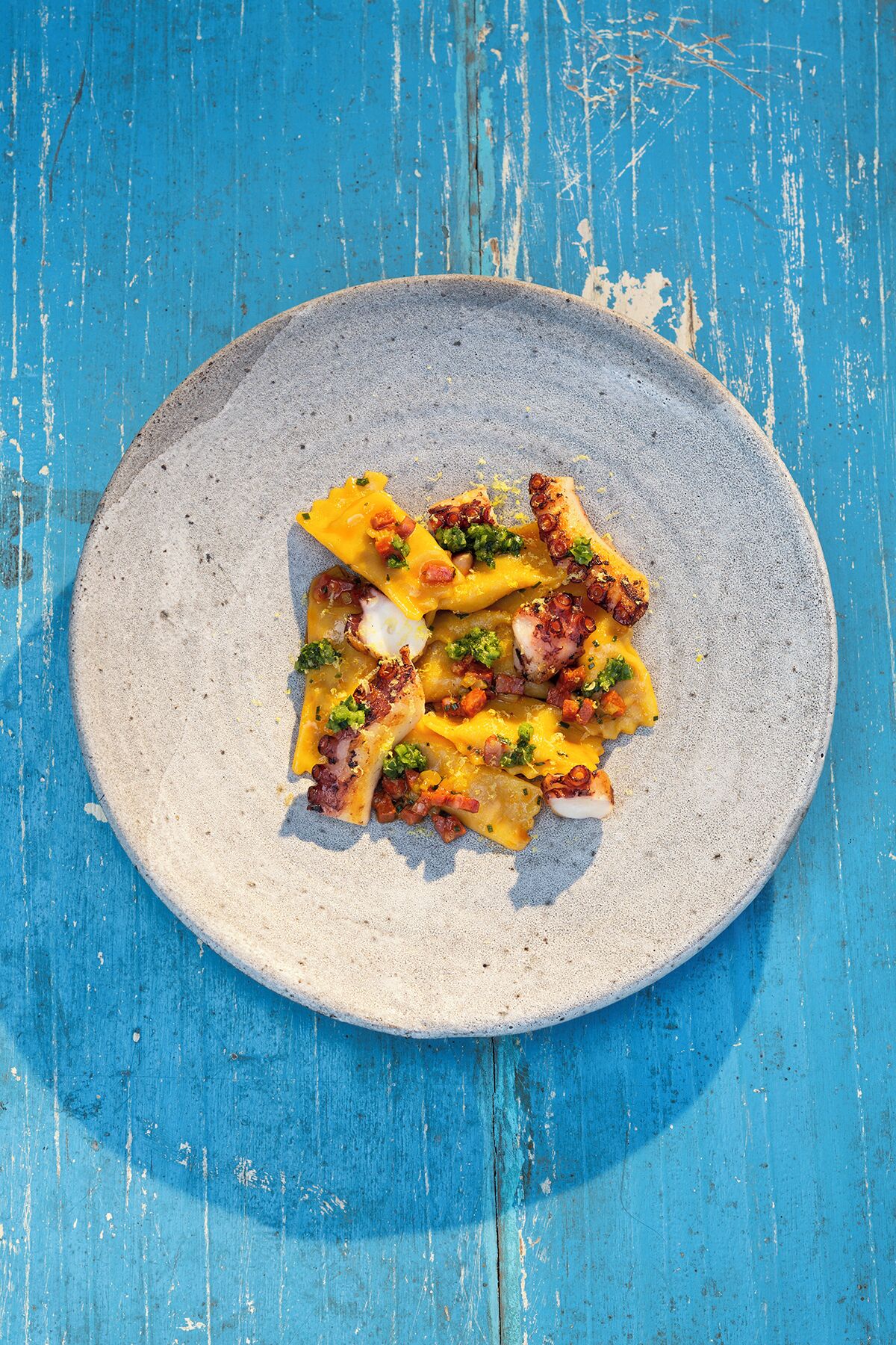 Une assiette de nourriture posée sur une surface en bois bleue.