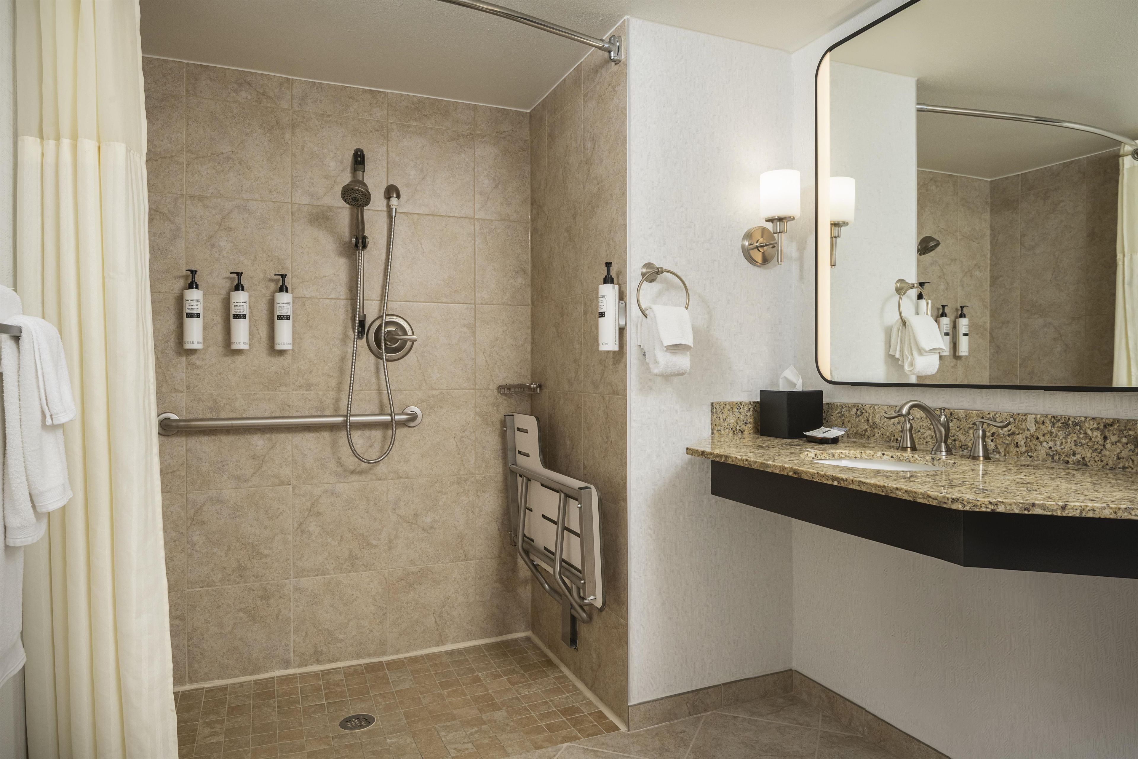 Een moderne badkamer met douche, toilet en wastafel.