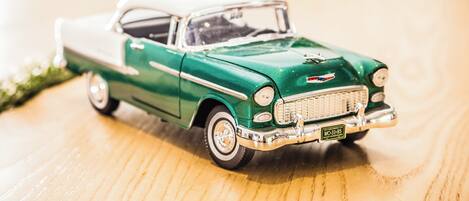 A green and white vintage car model on a wooden surface.