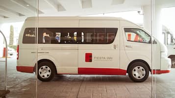 A white and red FIesta Inn business class van parked inside a building.