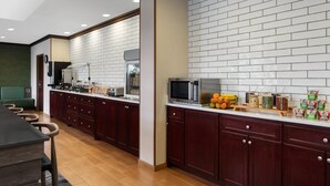 A modern kitchen with dark wooden cabinets, a white tiled backsplash, and a stainless steel microwave. - Fairfield Inn by Marriott Charlotte Mooresville (Mooresville)