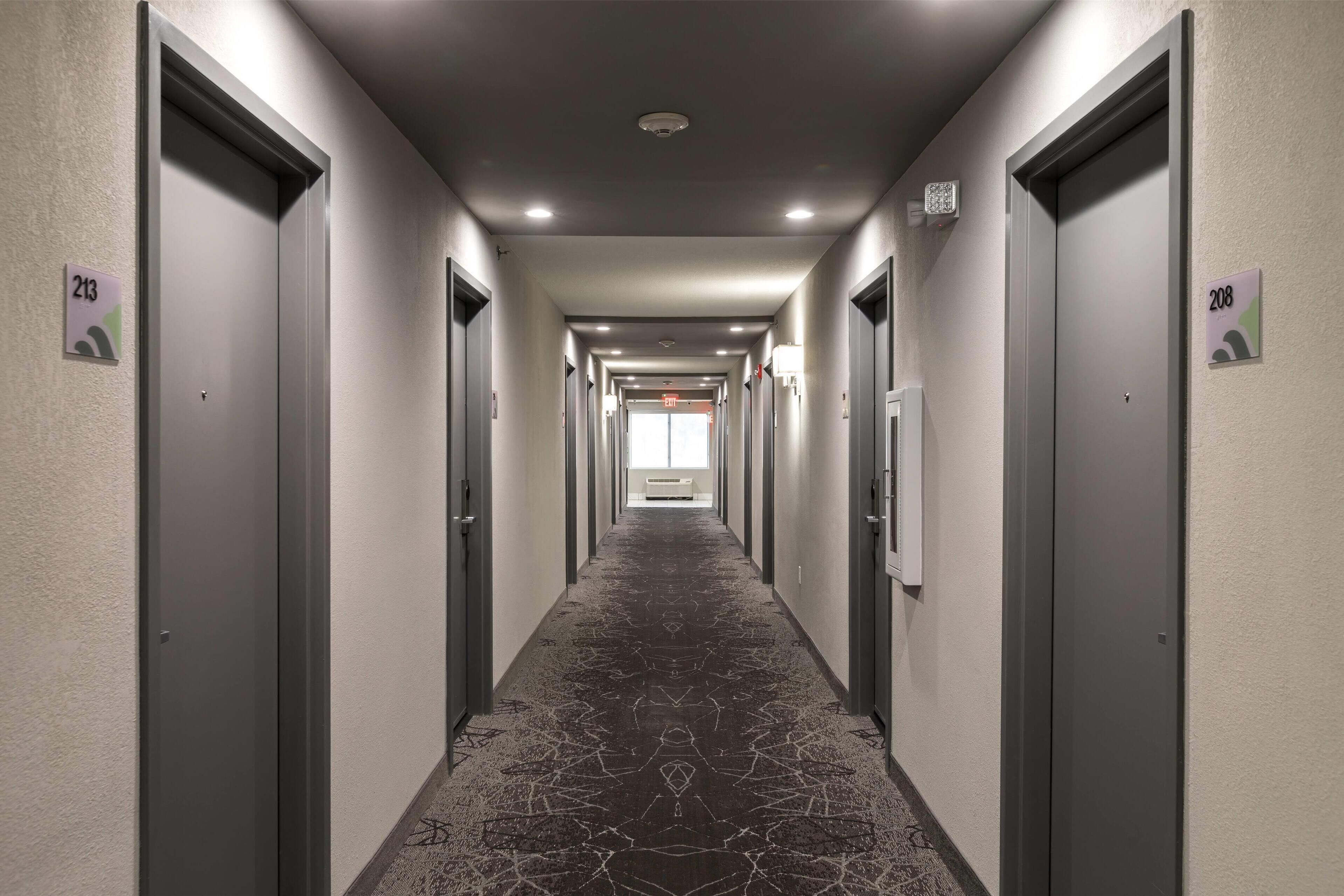 A hotel hallway with doors numbered 213 and 208, leading to rooms.