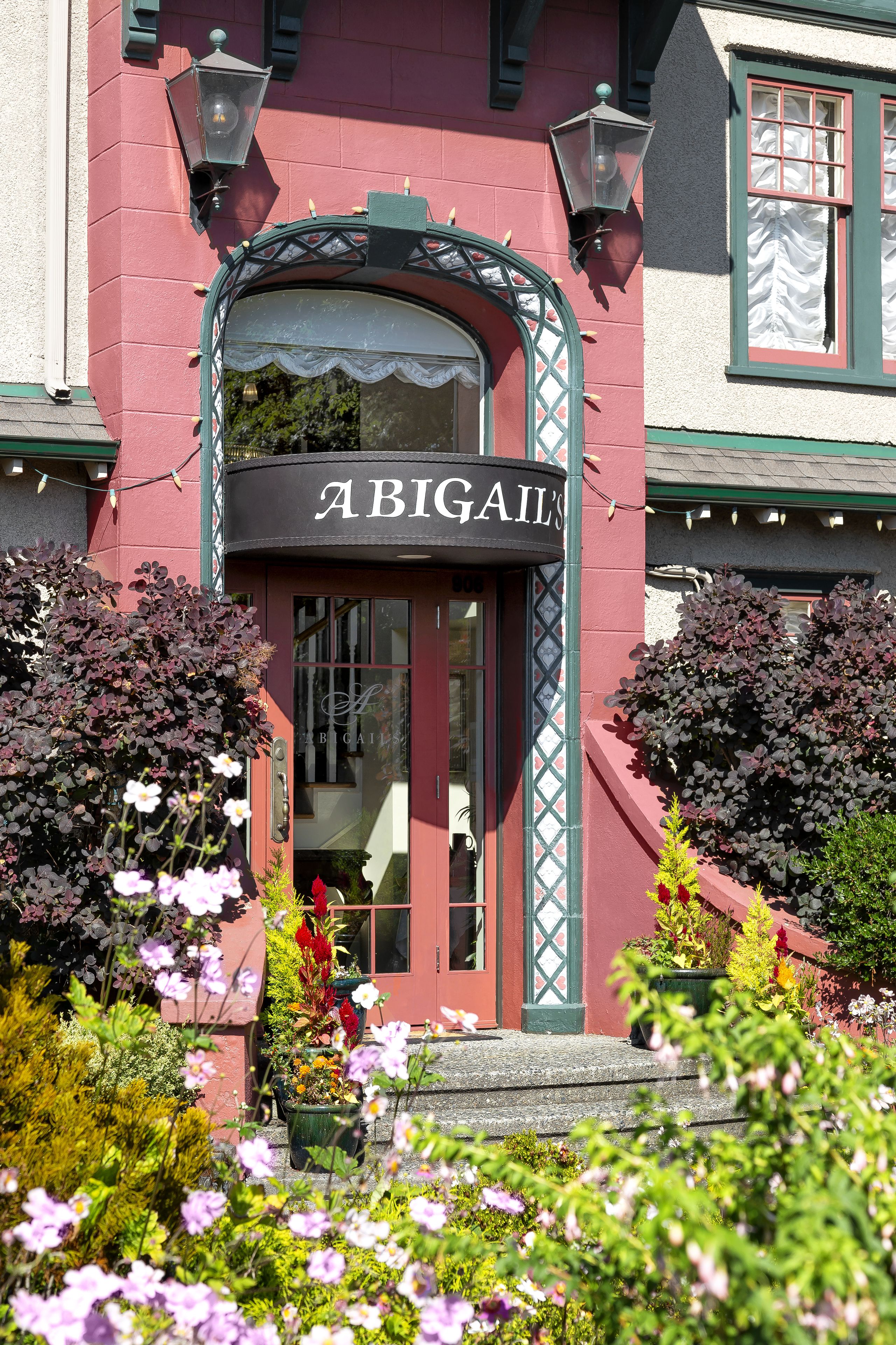 Ein Gebäude mit einem Schild, auf dem "ABIGAIL'S" steht, und einem großen Rundbogenportal.