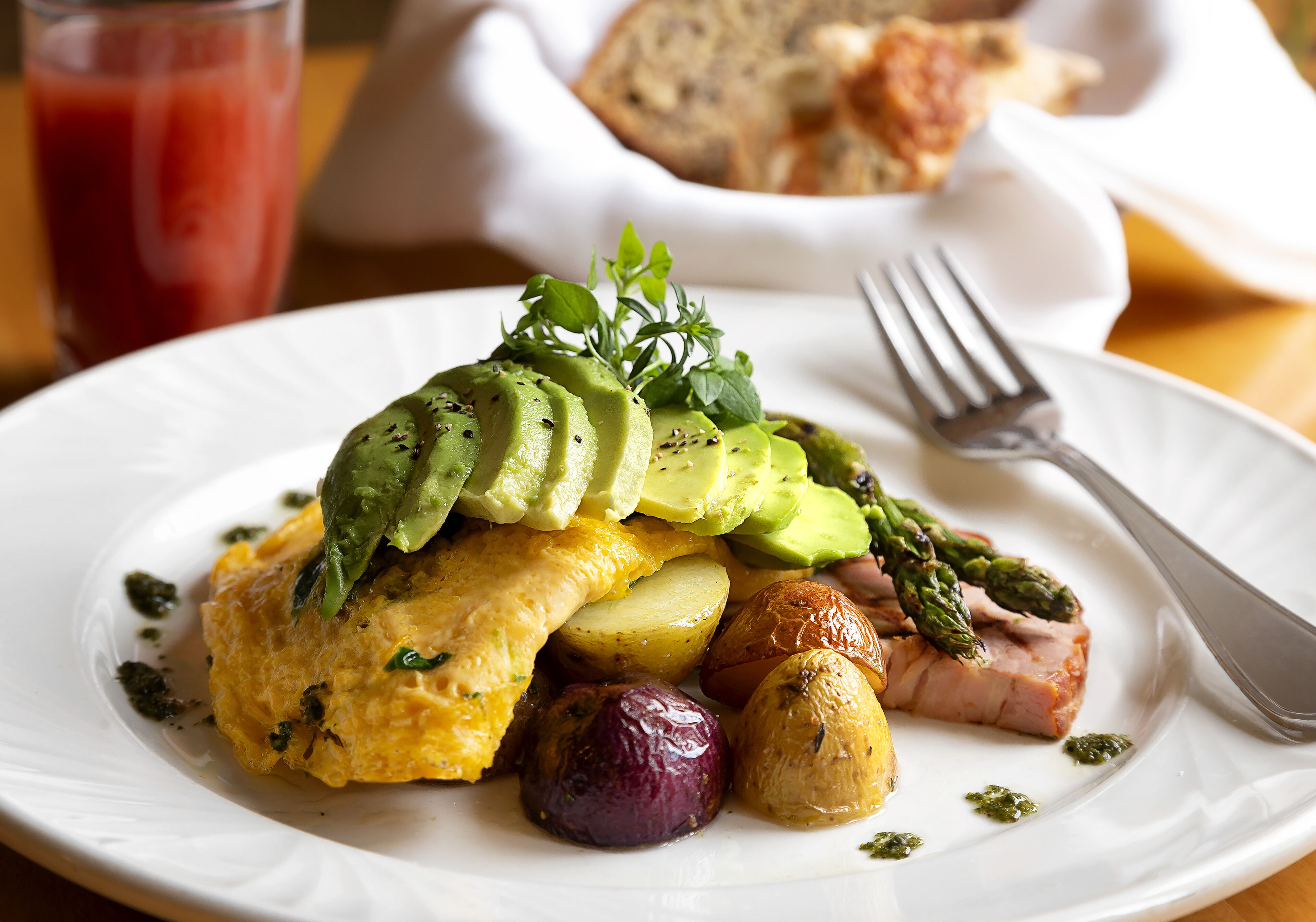 A plate with food including avocado, asparagus, and potatoes.