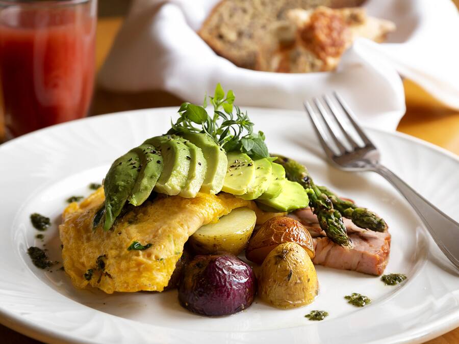 A plate with food including avocado, asparagus, and potatoes.