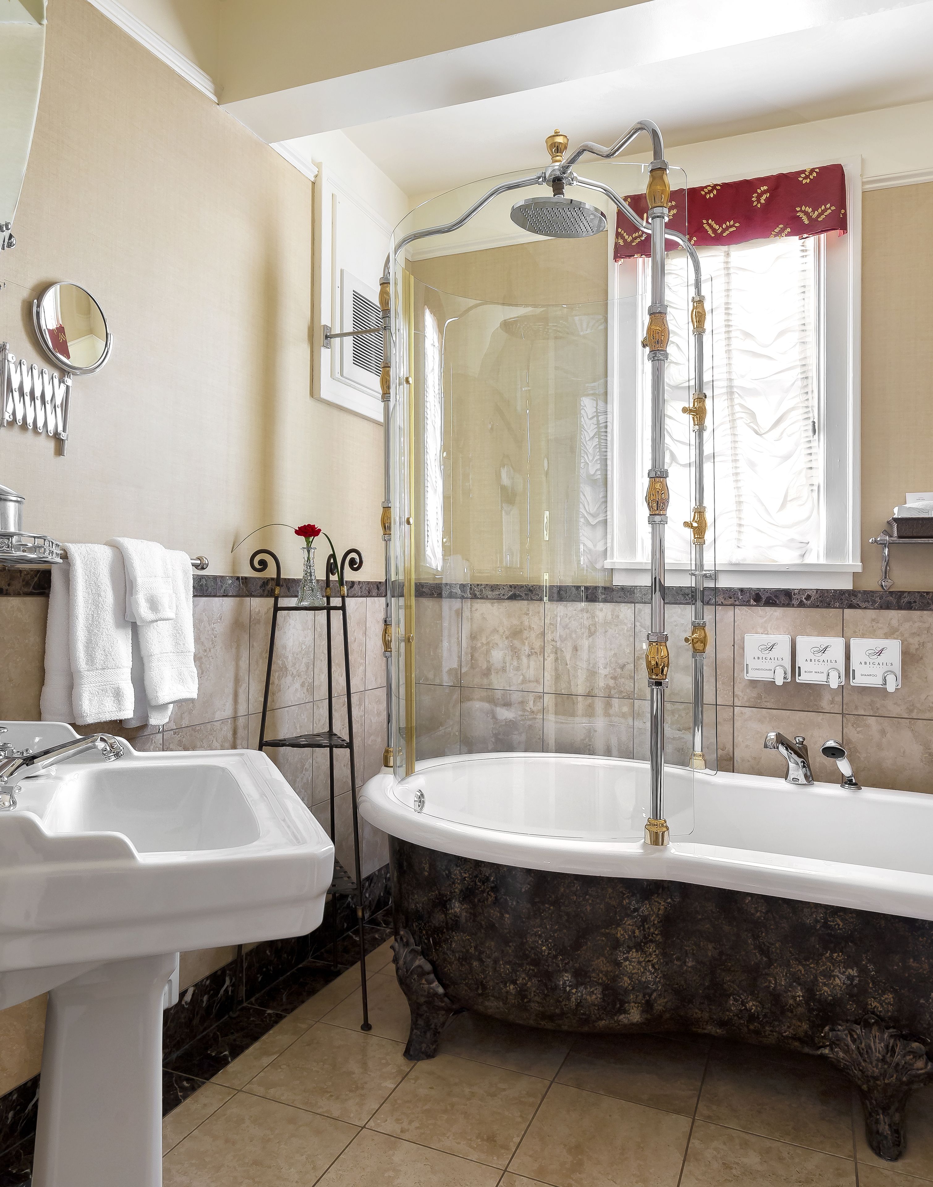 A bathroom with a freestanding bathtub, a pedestal sink, and a shower enclosure.