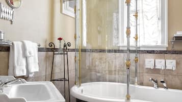 A bathroom with a freestanding bathtub, a pedestal sink, and a shower enclosure.