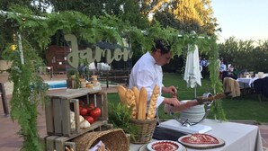 Un puesto de comida al aire libre con pan, tomates y platos de carne.