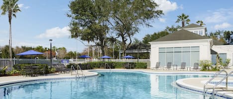 Una piscina al aire libre, sillones reclinables de piscina