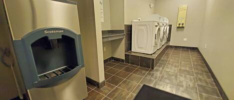 A restroom with a Scotman hand dryer, a soap dispenser, and a urinal.