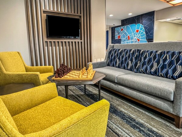 A modern living room with a chessboard, a sofa, and two armchairs. - Holiday Inn Express  Kearney by IHG (Kearney)