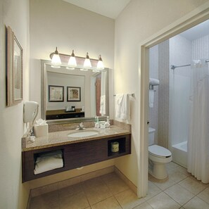 A hotel bathroom with a sink, mirror, and toilet.