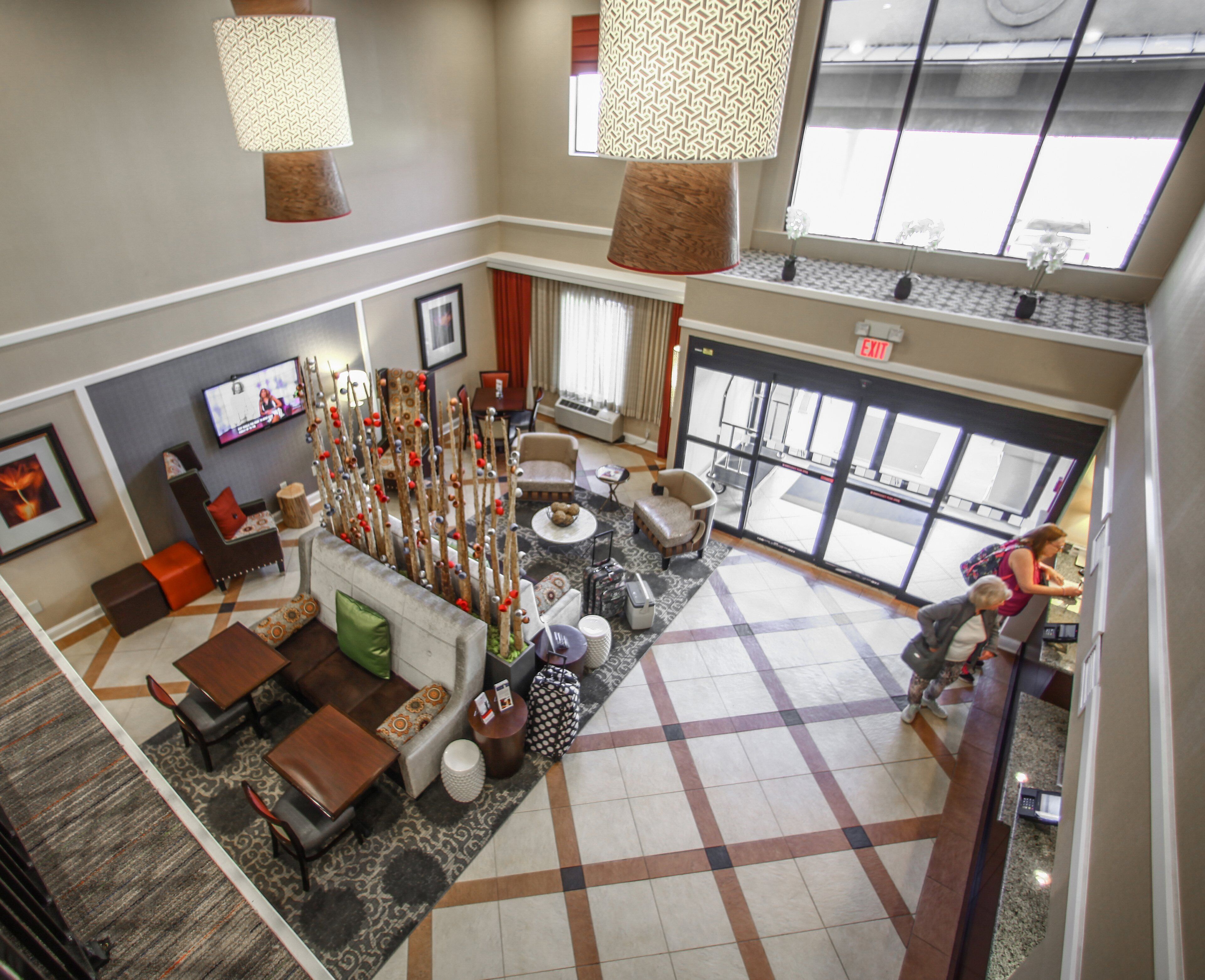 A hotel lobby with a seating area, a fireplace, and a large window.