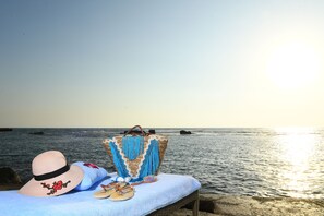 Relax by the ocean with a serene beach scene featuring a woven basket and a straw hat.