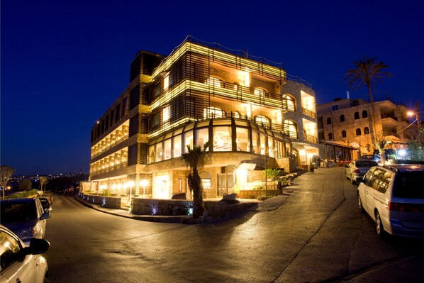 Experience the sleek, curved design of this hotel, featuring multiple balconies and a well-lit interior.