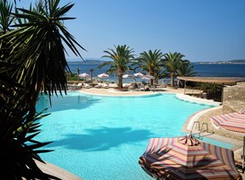 Una piscina techada, una piscina al aire libre de temporada, sombrillas