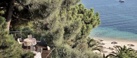 Terraza con asientos al aire libre con vista a una playa y al mar.