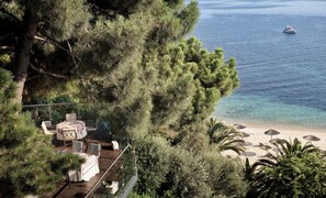Terraço com área de estar ao ar livre, vista para a praia e para o mar.