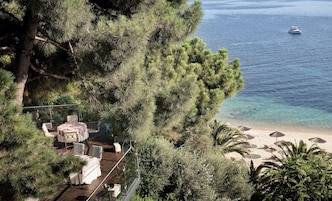 Terraza con asientos al aire libre con vista a una playa y al mar.