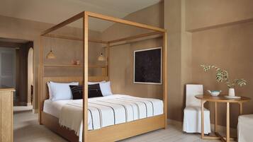 A four-poster bed with a wooden frame, white bedding, and a starry night sky painting on the wall.