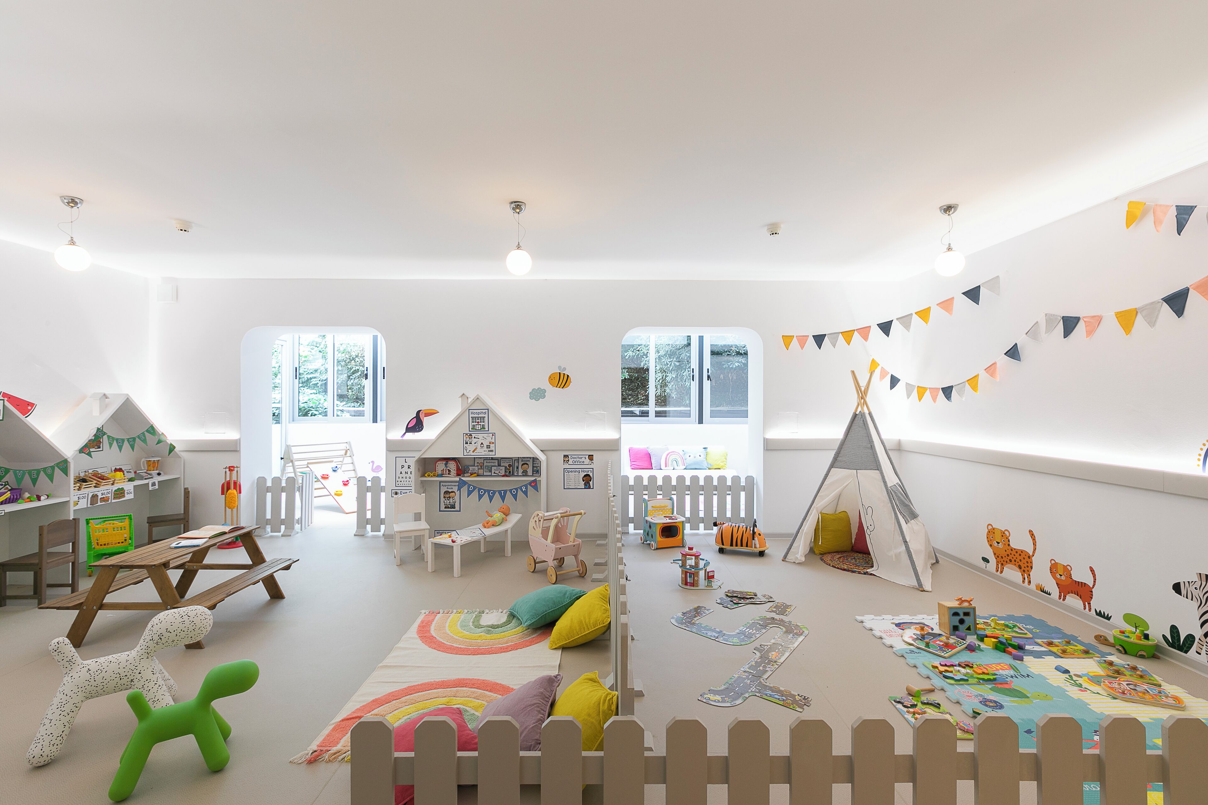 A bright, child-friendly room with a play area, a small table, and a window with a view.