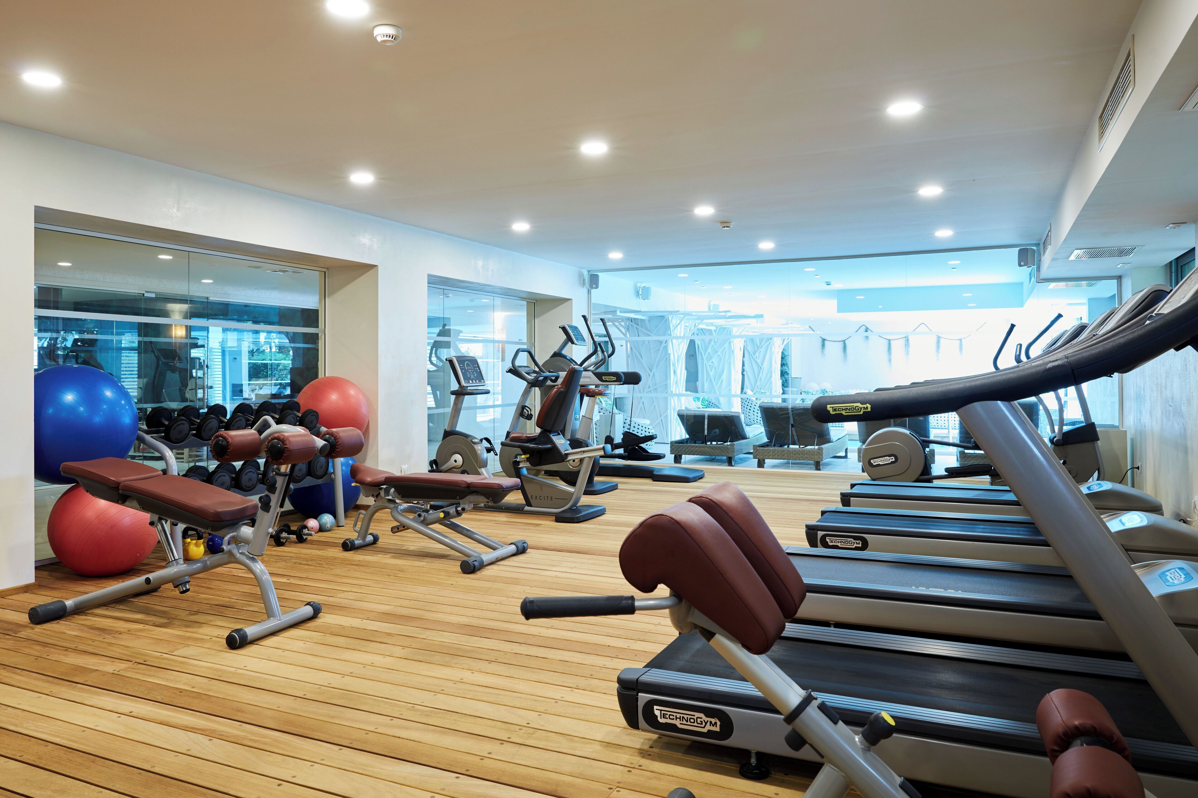 A gym with treadmills, elliptical machines, and free weights.