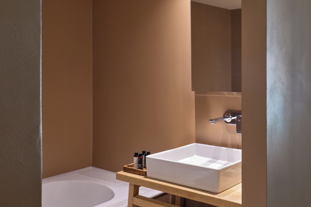 A modern bathroom with a bathtub, a sink, and a mirror.