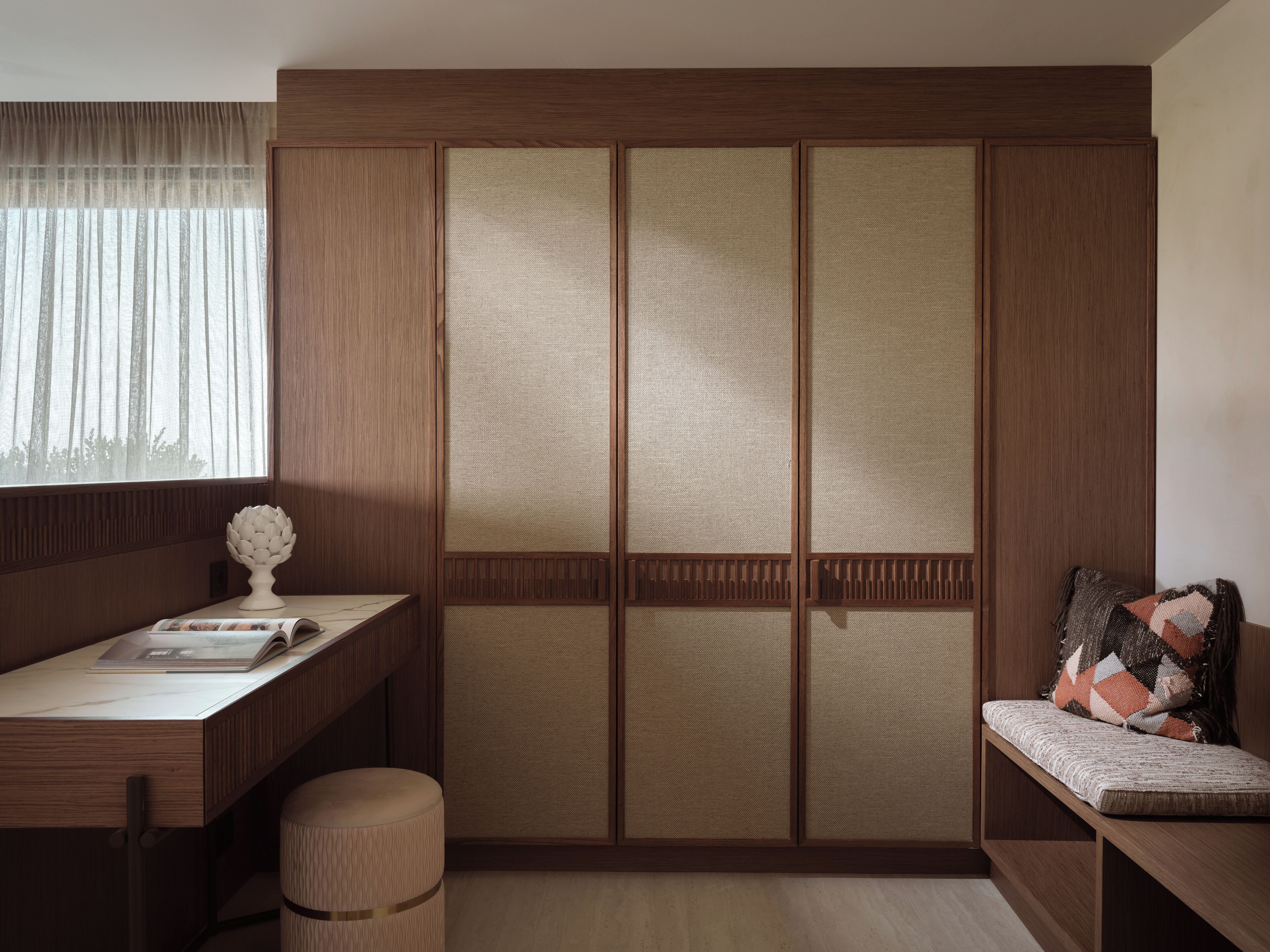 Una habitación japonesa tradicional con suelo de tatami, un bajo escritorio de madera, un banco acolchado y una puerta corredera estilo shoji.