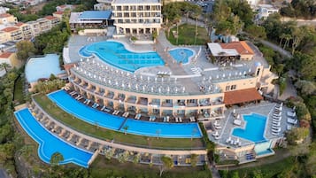 A resort with multiple swimming pools, a rooftop bar, and a large building with balconies.