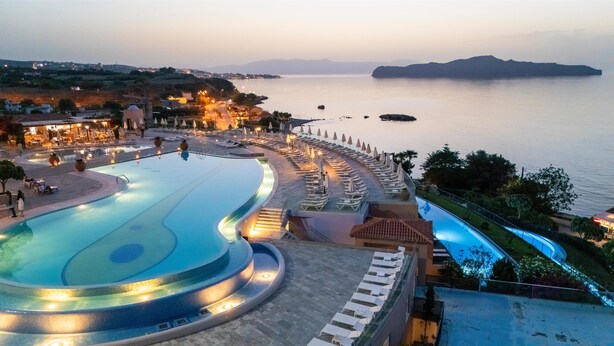 A resort with a large infinity pool, a beach area with sun loungers, and a view of the sea. - Leptos Panorama Hotel (Chania)