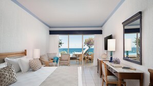 A hotel room with a bed, a desk, and a view of the ocean. - Leptos Panorama Hotel (Chania)