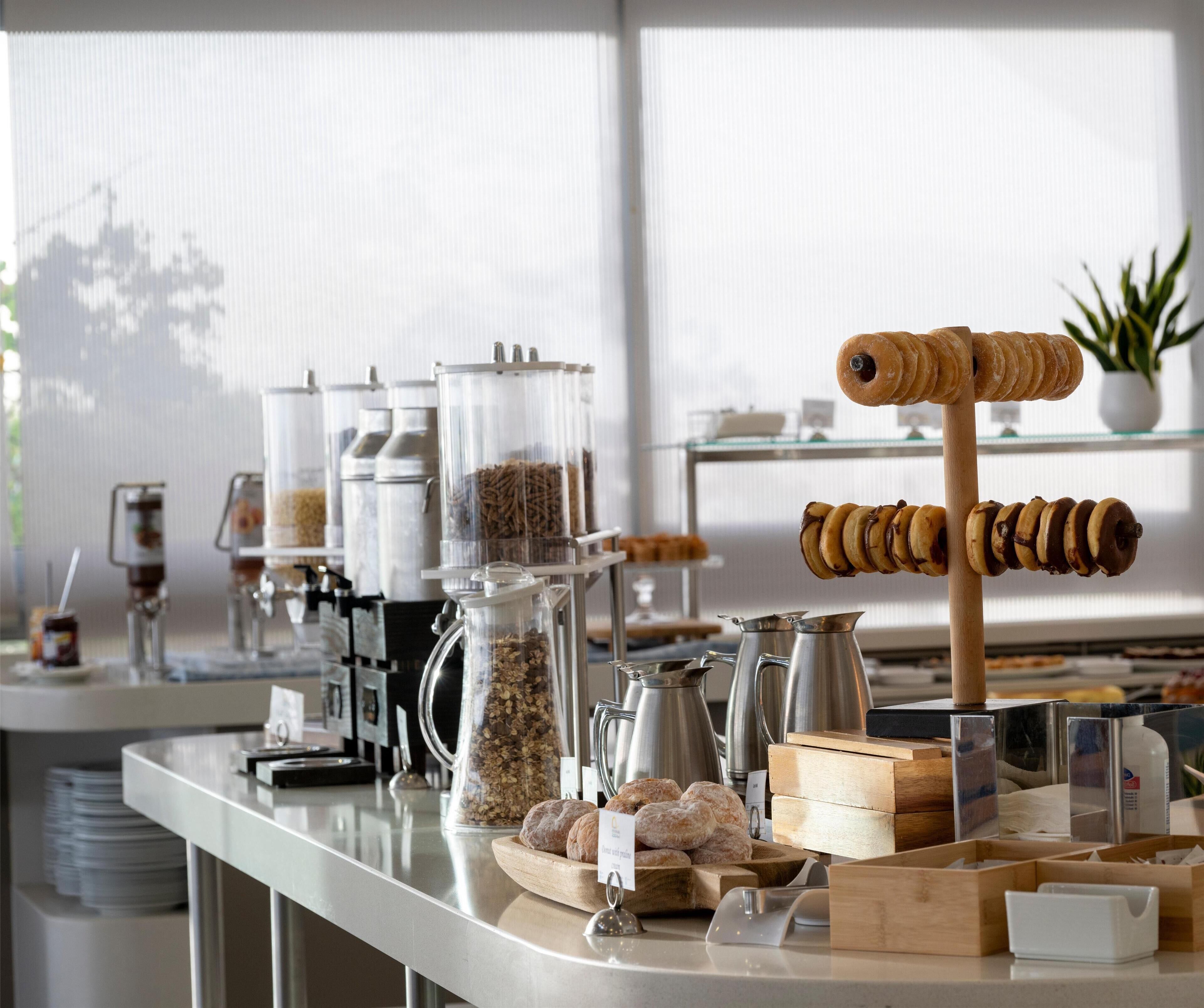 Un bufé de desayuno con diversas opciones de comida y máquinas de café.