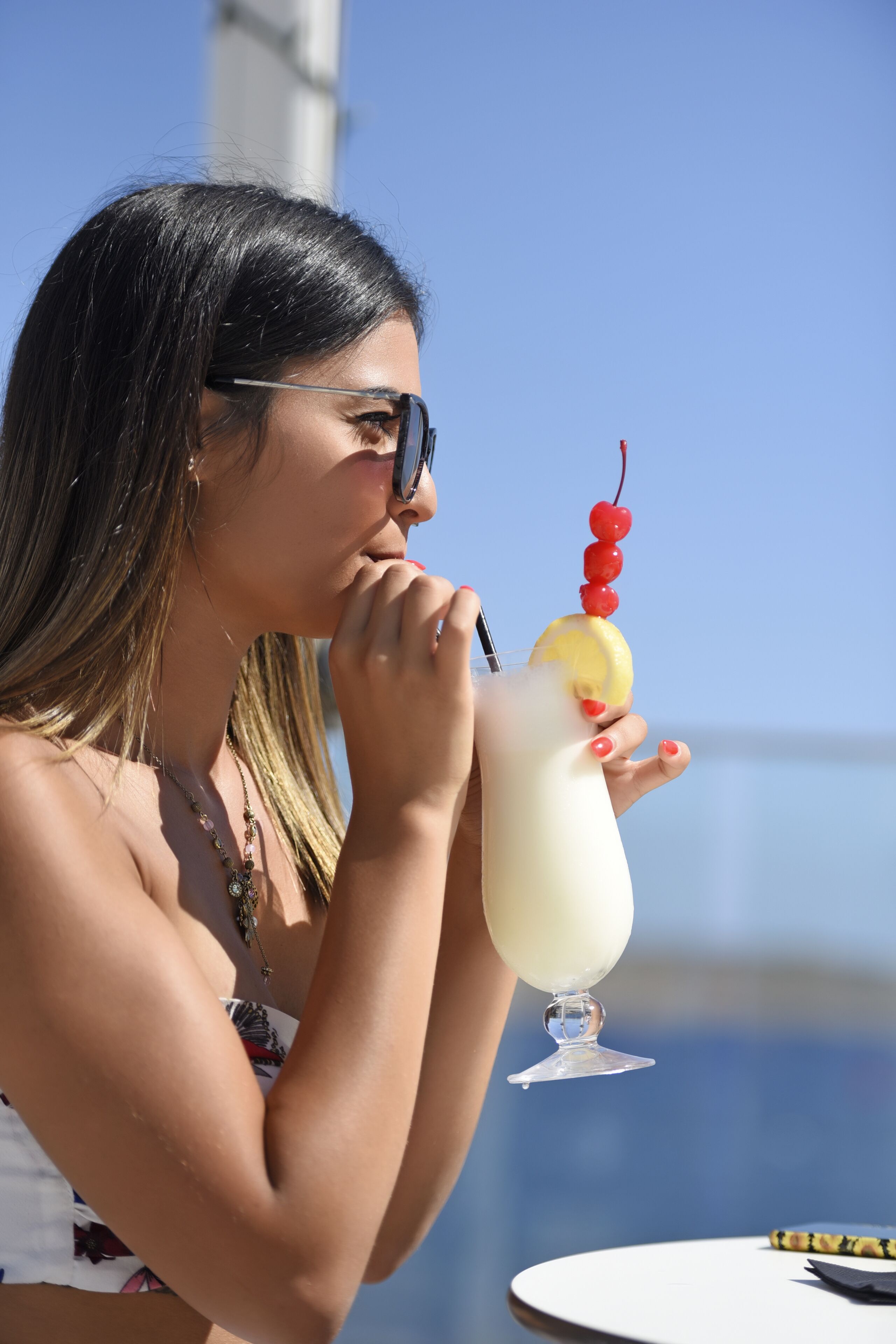 Iemand houdt een cocktail met een kers.